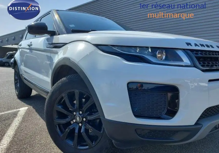 Vue 3/4 avant gauche d'un Range Rover Evoque blanc de 2018 avec jantes noires et calandre distinctive.