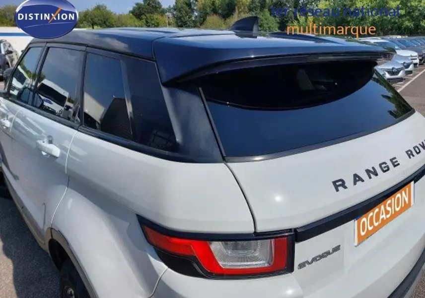 Vue 3/4 arrière droite d'un Range Rover Evoque blanc 2018 avec toit noir et feux arrière distinctifs rouges.