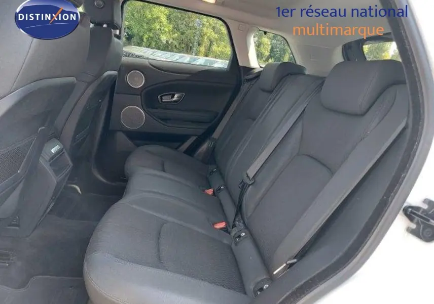 Vue intérieure arrière côté droit du Range Rover Evoque blanc de 2018, montrant les sièges arrière en tissu noir.