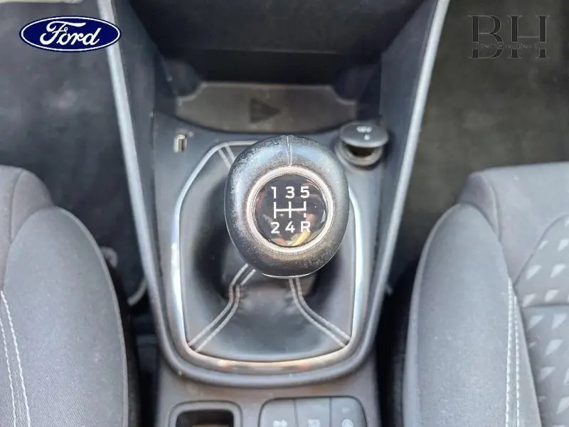 Levier de vitesse manuel noir vu de dessus dans une Ford Fiesta 2021 gris Fashion Magnetic, entre sièges avant en tissu.