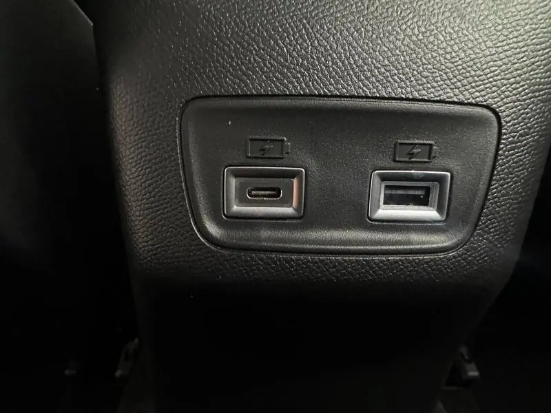 Prise USB-C et USB-A pour recharge rapide, vue en gros plan sur la console arrière noire d'une Peugeot 208 1.2 Hybrid 110ch GT 2025.