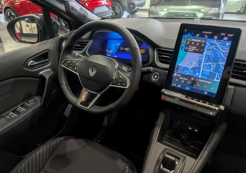 Vue intérieure côté conducteur du Renault SYMBIOZ gris Cassiopé, avec tableau de bord numérique et grand écran tactile central.