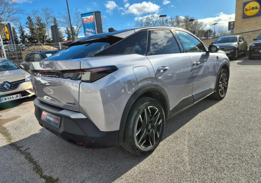 Peugeot 3008 Hybrid gris clair en 3/4 arrière droit, avec jantes alliage 19 pouces et toit noir contrasté.