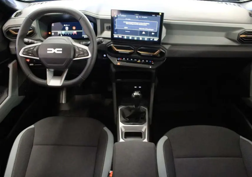 Vue intérieure avant du Dacia Bigster 2026 gris schiste, avec tableau de bord digital et boîte manuelle visible.