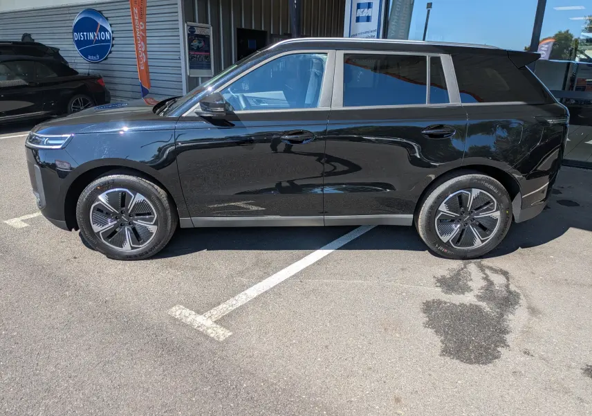 Vue de profil côté gauche du SUV JAECOO J5 noir carbone métal, avec jantes modernes et vitres teintées.