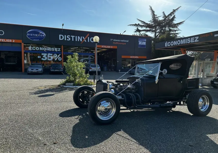 Vue 3/4 avant droite d'une Ford T Hot Rod V8 noire avec capote relevée et jantes chromées brillantes.