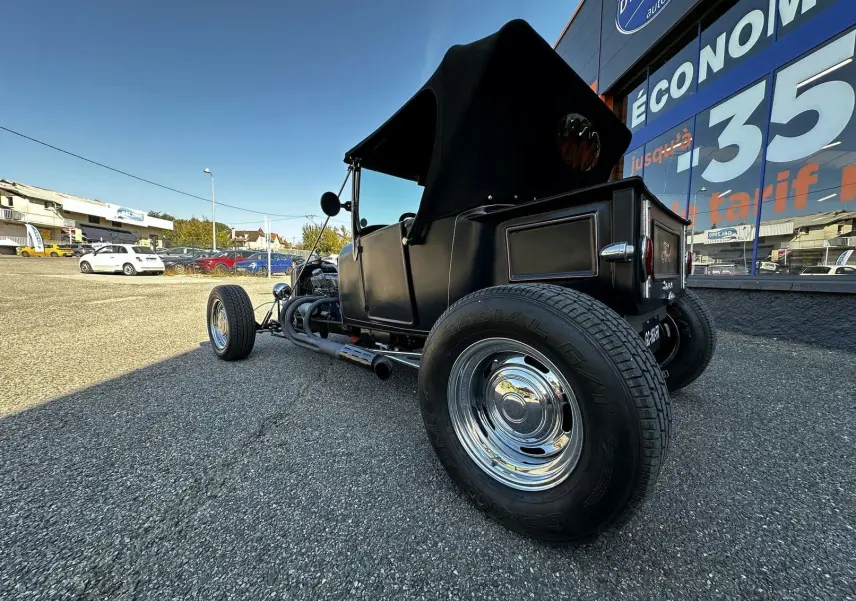 Vue 3/4 arrière droite du Ford T Hot Rod V8 noir décapotable, mettant en valeur ses roues chromées et son style vintage.