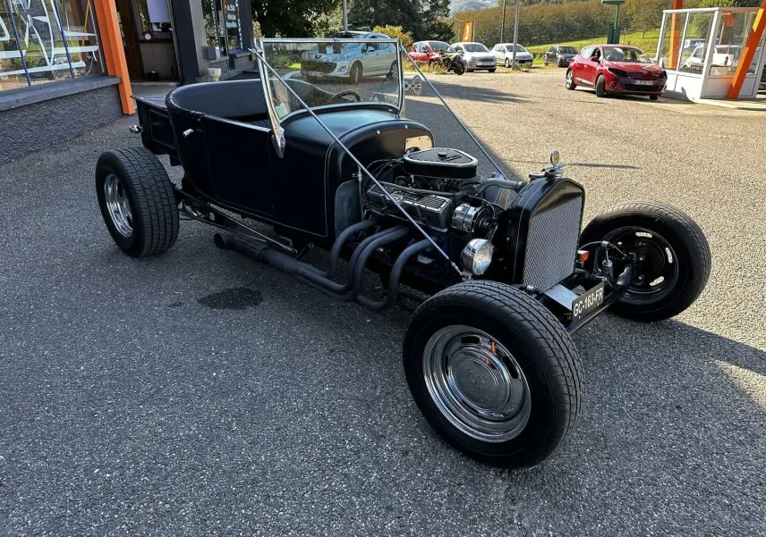 Ford T Hot Rod V8 noir vue 3/4 avant droit, moteur apparent et carrosserie décapotable avec liserés faits main.