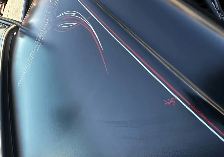 Détail de la peinture noire avec liserés rouges et blancs faits à la main sur le capot d'un Ford T Hot Rod V8 1923.