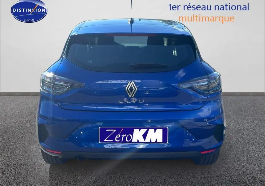 Vue arrière d'une Renault Clio V bleu iron avec feux arrière LED et becquet intégré sur fond neutre.