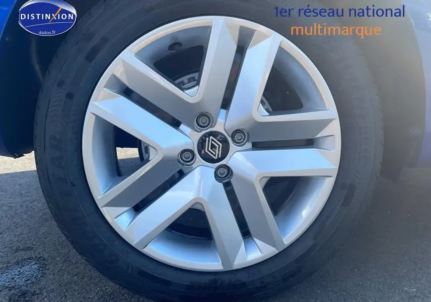 Gros plan sur la roue avant droite de la Renault Clio V bleu iron, mettant en valeur la jante alliage moderne.