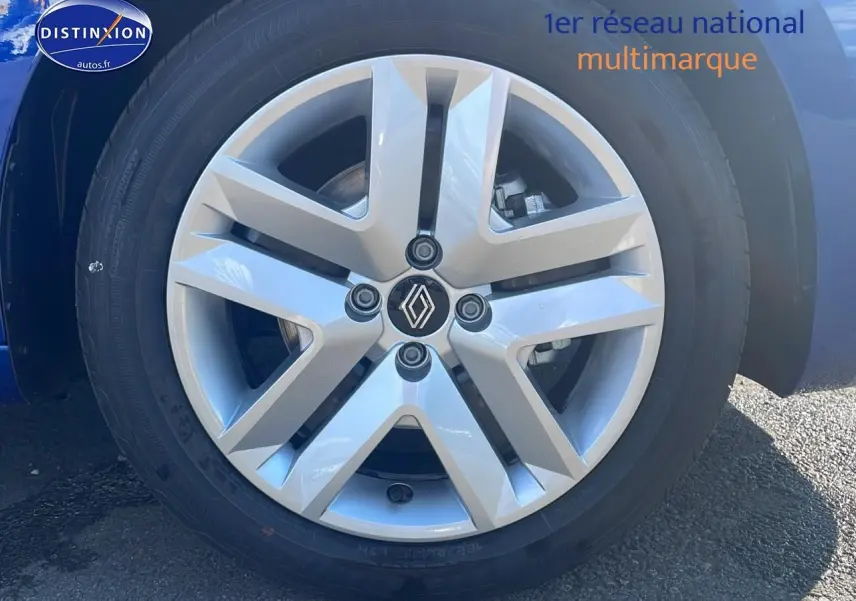 Gros plan sur la jante alliage argentée d'une Renault Clio V Bleu Iron, avec logo Renault au centre.