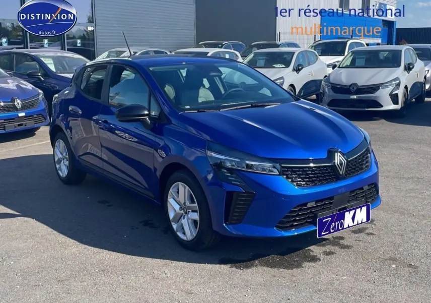 Renault Clio V bleu iron vue 3/4 avant droit, avec calandre noire et jantes argentées, stationnée en extérieur.