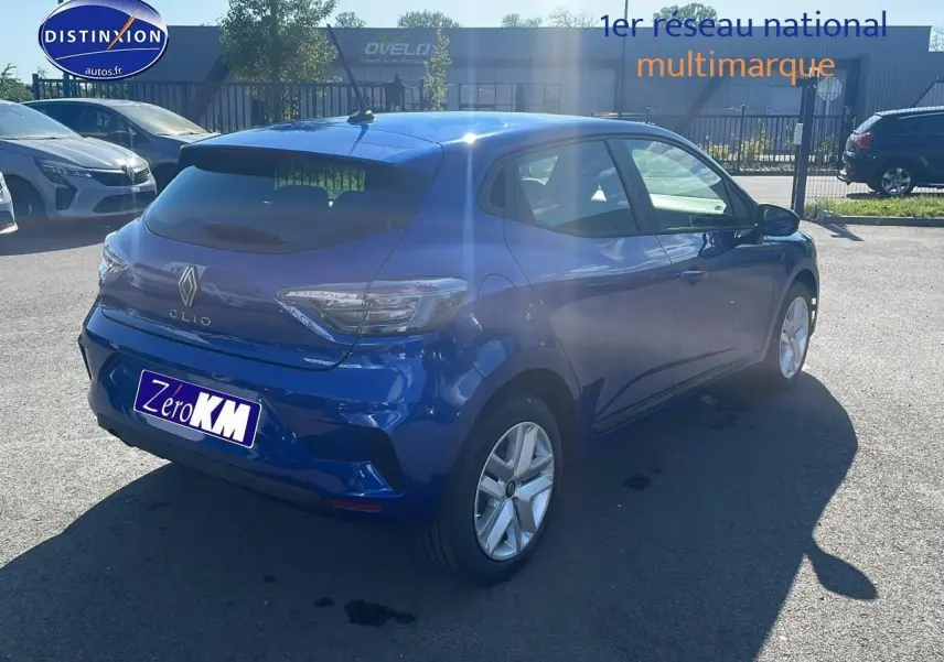 Vue 3/4 arrière droite d'une Renault Clio V bleu iron stationnée en extérieur avec jantes argentées.