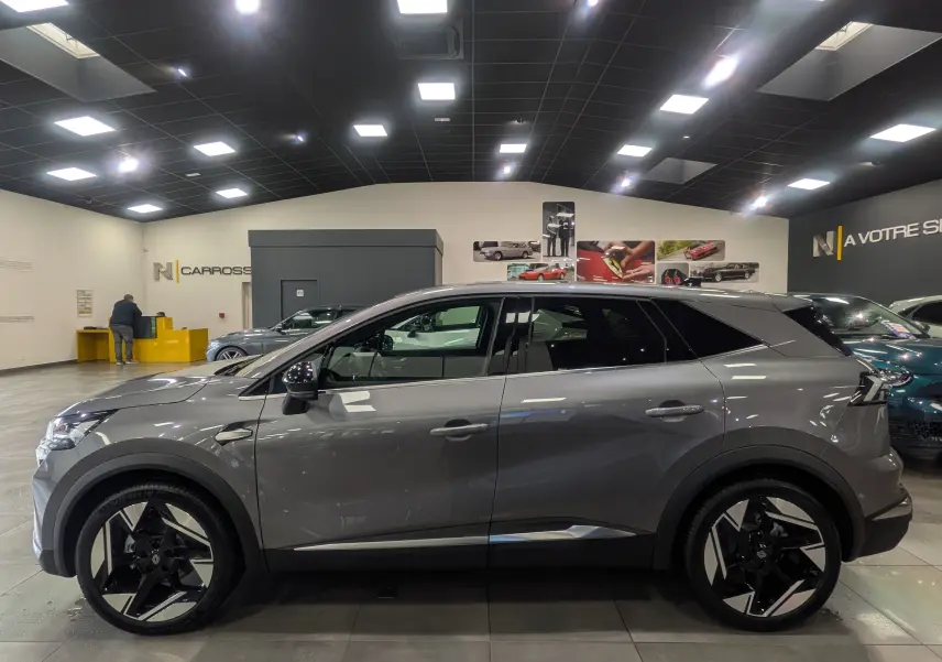 Profil côté gauche du Renault SYMBIOZ gris Cassiopé 2025 en hybride, avec jantes noires et blanches distinctives.