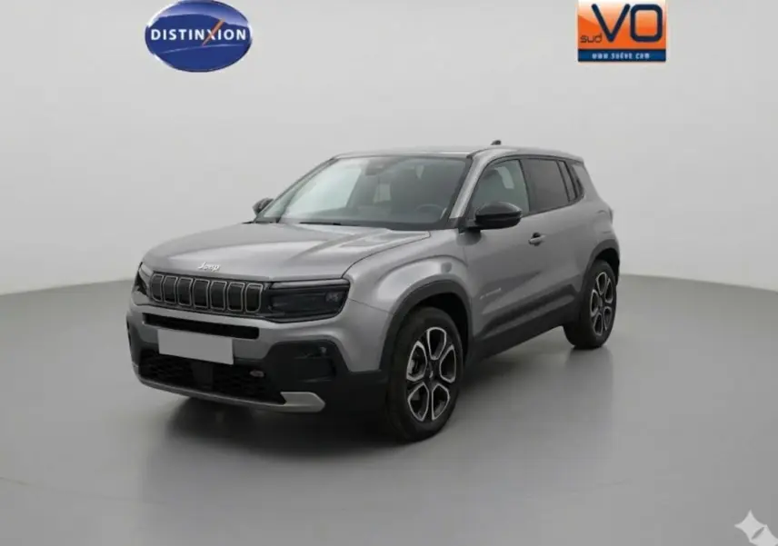 Jeep Avenger gris en 3/4 avant droit, avec jantes alliage noires et détails noirs sur la calandre et les rétroviseurs.