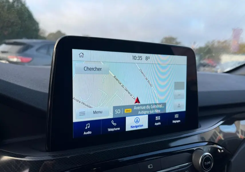 Écran tactile central du Ford Kuga 2022 affichant la navigation, avec tableau de bord noir et finitions carbone.