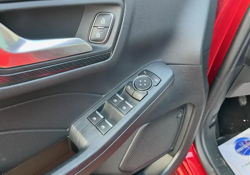 Détail de la porte côté conducteur du Ford Kuga rouge Lucifer 2022, montrant les commandes des vitres et la poignée intérieure.