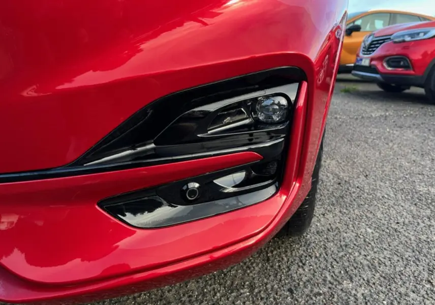 Gros plan sur le projecteur antibrouillard avant droit du Ford Kuga 1.5 EcoBoost rouge Lucifer avec insert noir brillant.