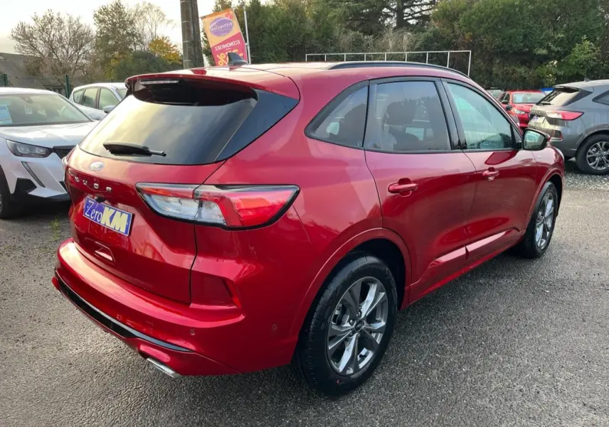 Vue 3/4 arrière droite d'un Ford Kuga 1.5 EcoBoost ST-Line rouge Lucifer avec vitres arrière surteintées et jantes alliage 18 pouces.
