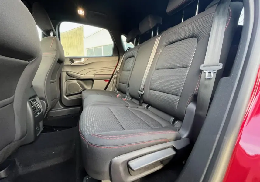 Vue intérieure côté droit sur la banquette arrière noire avec surpiqûres rouges du Ford Kuga 1.5 EcoBoost rouge Lucifer 2022.