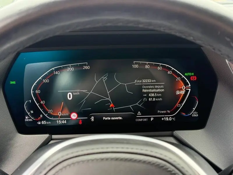 Vue rapprochée du tableau de bord numérique de la BMW Série 1 118dA 2022 avec affichage de la vitesse et navigation.