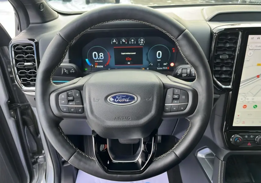 Vue rapprochée du volant cuir noir du Ford Ranger 2026 avec tableau de bord numérique et écran central tactile.