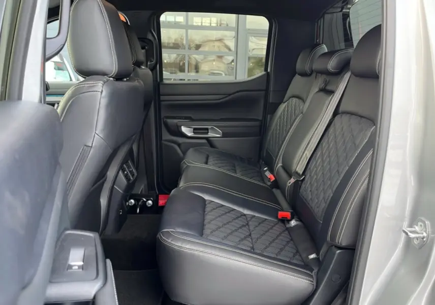 Vue latérale intérieure arrière du Ford Ranger 2026 gris iconic, montrant les sièges en cuir noir matelassé avec surpiqûres contrastantes.