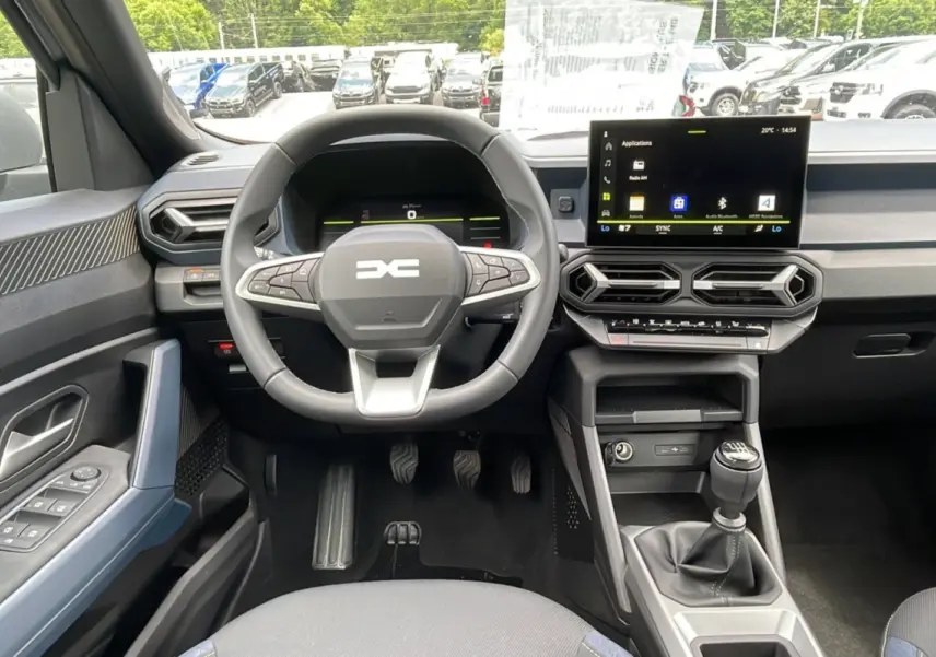 Vue intérieure avant centrée sur le volant cuir et la console avec écran tactile du Dacia Bigster 2025.