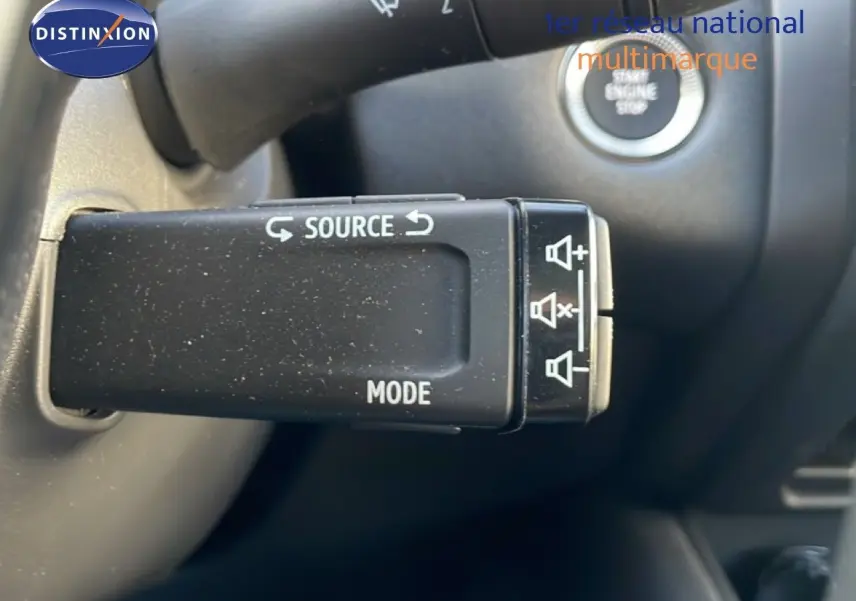 Gros plan sur la commande au volant du Renault Symbioz gris cassiopée, avec bouton source et mode visible.