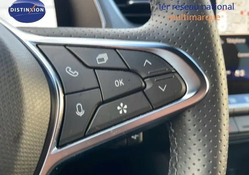 Gros plan sur les commandes au volant en cuir perforé du Renault Symbioz gris cassiopée métal, version hybride 2025.