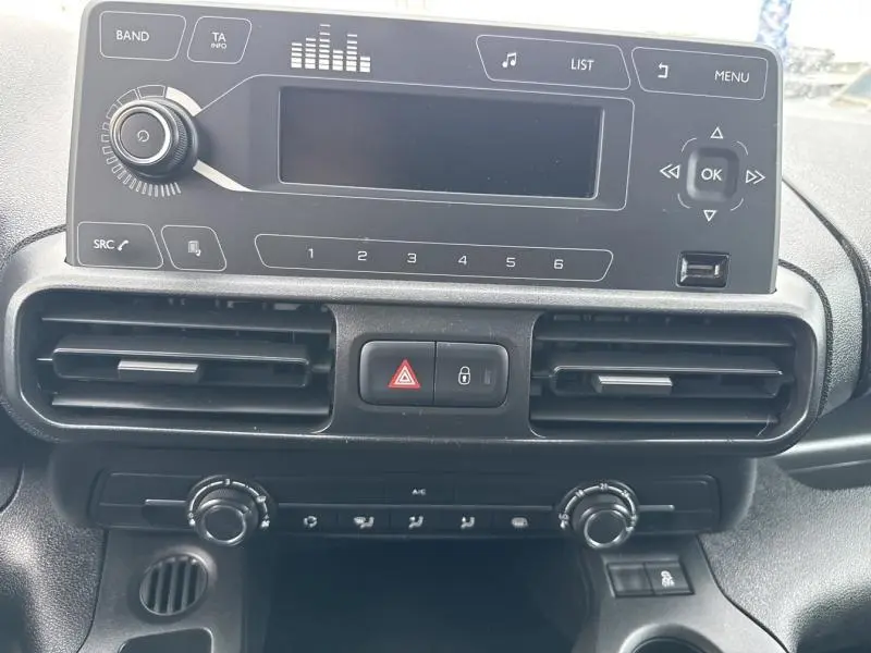 Vue rapprochée du tableau de bord noir du Citroën Berlingo Fourgon 2020 avec commandes radio et climatisation.