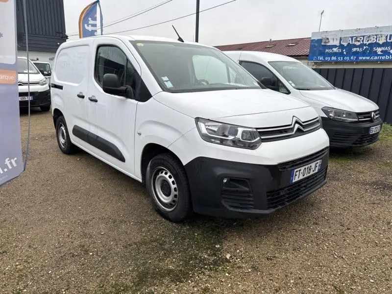 Citroën Berlingo Fourgon blanc banquise vu en 3/4 avant droit sur parking avec calandre et phares visibles.