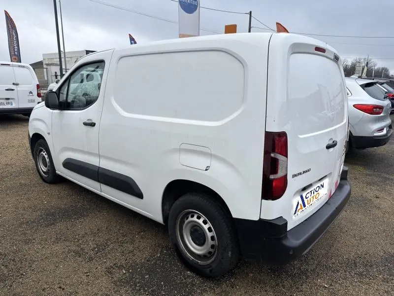 Vue 3/4 arrière droite d'un Citroën Berlingo Fourgon blanc Banquise avec portes battantes et jantes tôles grises.