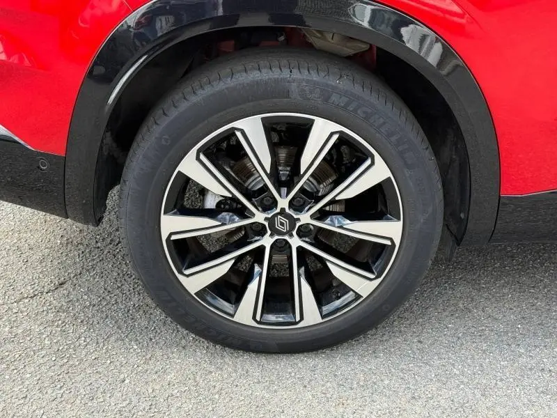 Gros plan sur la roue avant droite du Renault Austral Rouge Flamme 2025, avec jante alliage bicolore distinctive.