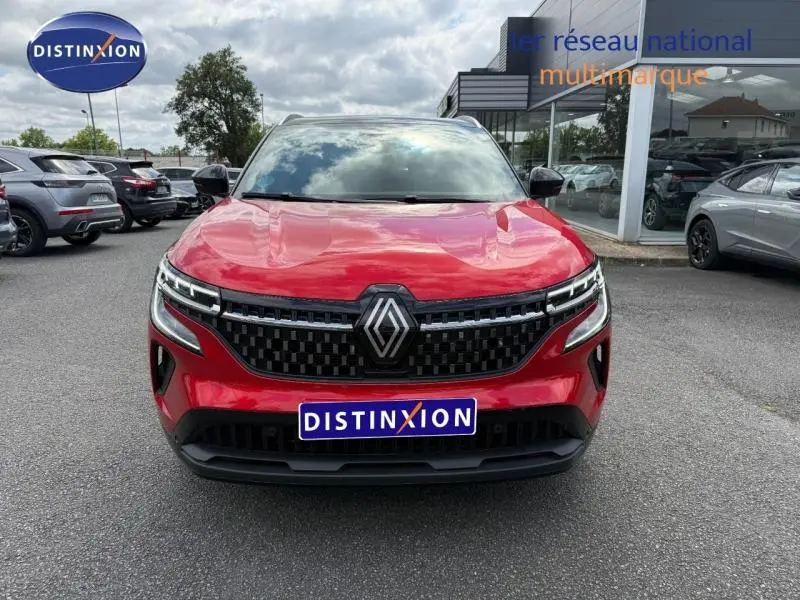 Vue avant d'un Renault Austral 2025 Rouge Flamme avec calandre noire à damier et logo central proéminent.