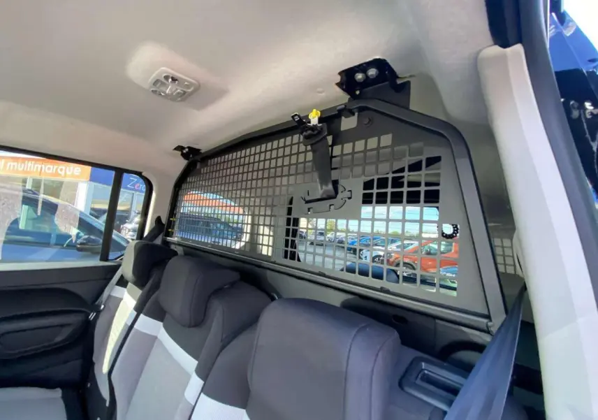 Vue intérieure côté droit du Citroën Berlingo 2026 avec banquette arrière et grille de séparation noire.