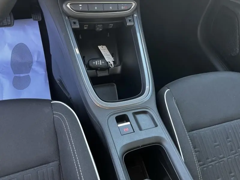 Vue intérieure centrée sur la console centrale et le frein à main électrique de la Fiat 600 T-Gen 3 beige 2025.