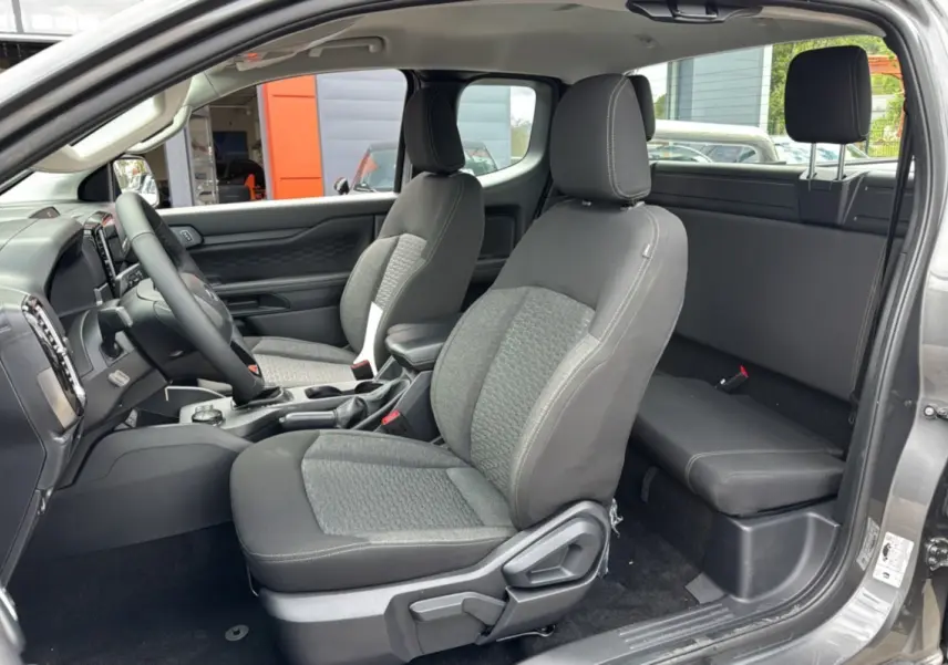 Vue intérieure côté conducteur du Ford Ranger gris carbone 2026, montrant les sièges avant et la banquette arrière compacte.