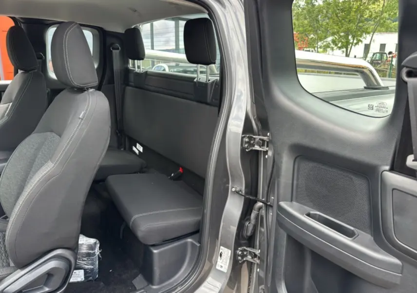 Vue intérieure côté arrière droit du Ford Ranger gris carbone, montrant les sièges et la porte ouverte.