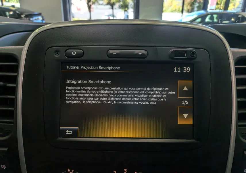 Écran tactile central du tableau de bord du Renault Trafic blanc, affichant un tutoriel d’intégration smartphone.