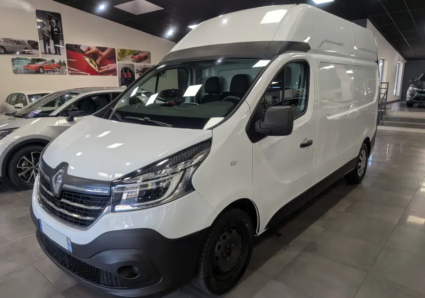 Fourgon Renault Trafic L2H2 blanc glacier vu en 3/4 avant droit dans un showroom lumineux.