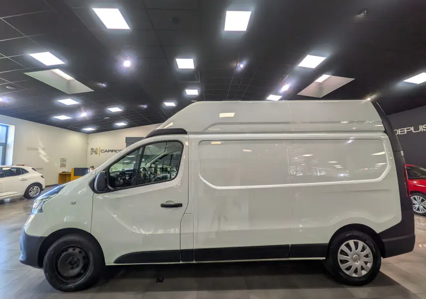 Renault Trafic Fourgon blanc glacier en vue profil côté gauche, fourgon utilitaire avec toit surélevé dans un showroom.