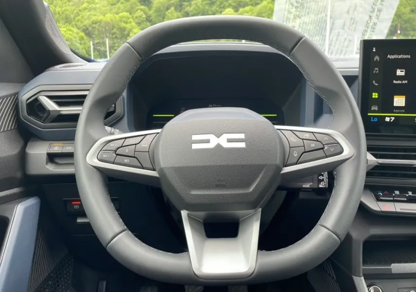 Vue centrée sur le volant cuir du Dacia Bigster 2025, avec tableau de bord numérique et écran tactile visible.