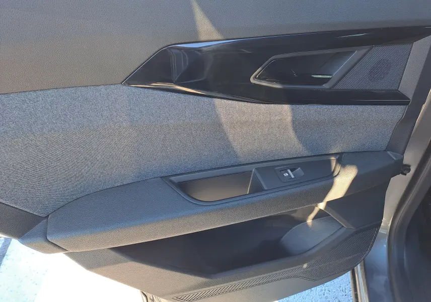 Détail de la porte intérieure côté gauche du Renault Austral gris schiste, avec habillage tissu et commande de vitre.