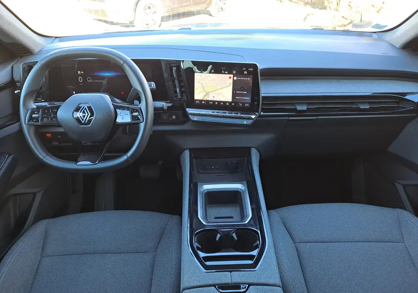 Vue intérieure avant du Renault Austral 2023, tableau de bord moderne avec écran tactile et volant multifonction en tissu gris.