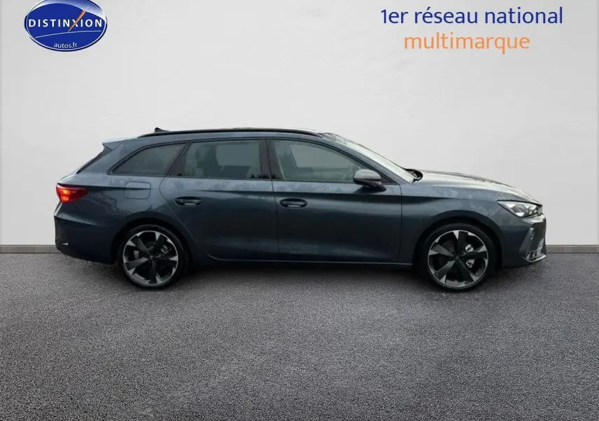 Vue latérale droite d'une CUPRA LEON ST 1.5 etsi hybrid gris magnétique avec jantes alliage et barres de toit.