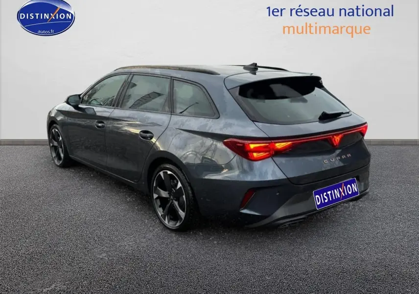 Vue 3/4 arrière droite d'une CUPRA LEON ST 2025 gris magnétique avec feux arrière LED allumés.