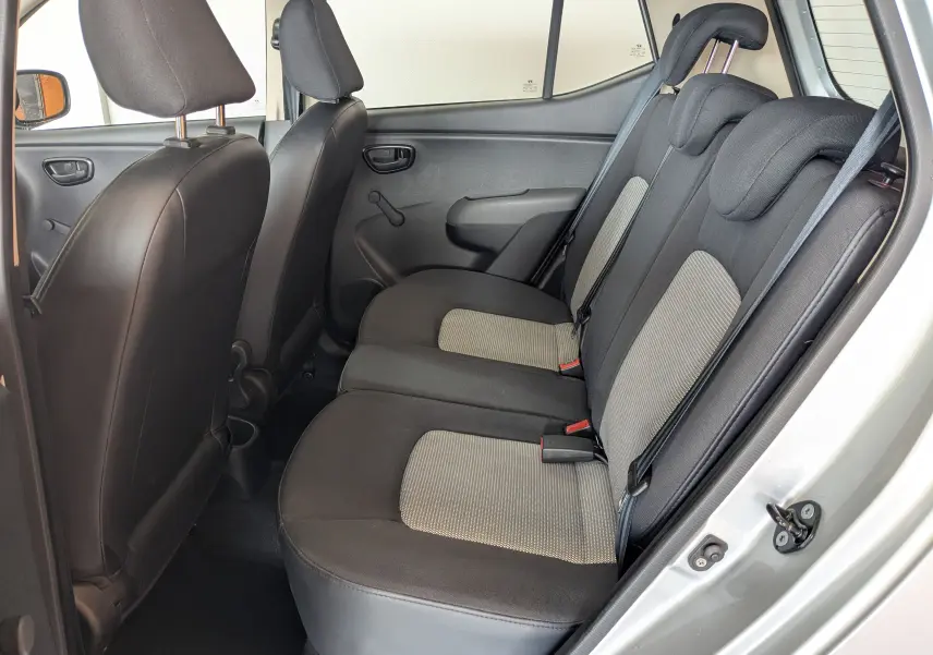 Vue intérieure côté droit des sièges arrière en tissu gris et noir d'une Hyundai i10 gris clair 2010 à 5 portes.