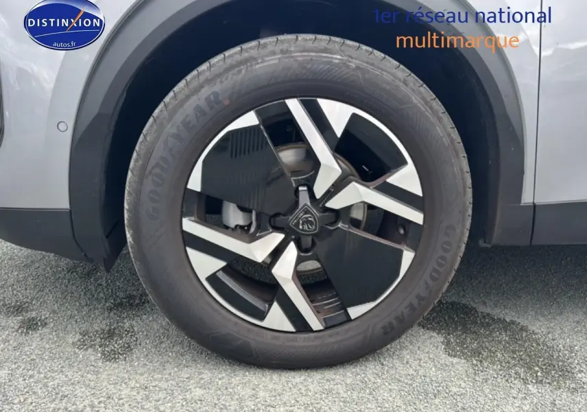 Gros plan sur la roue avant gauche du Peugeot 2008 gris Artense avec jante alu au design moderne.